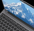 15.6-inch gray laptop with black keyboard and mountain wallpaper on display.